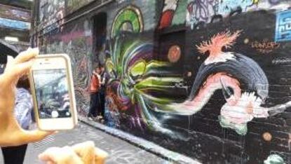 Tourists photographing graffiti at Centre Place Melbourne